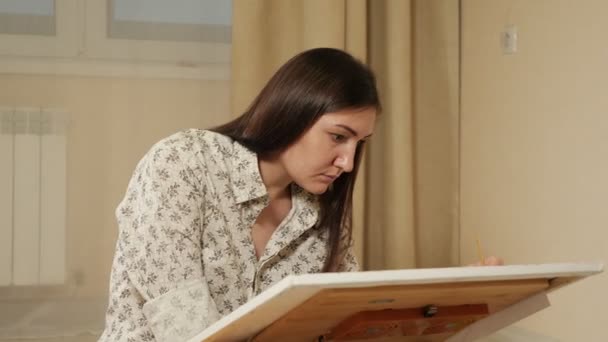 Красивая молодая женщина рисует картину — стоковое видео