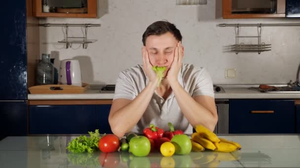 Грустный голодный человек ест свежий салат, следуя здоровой диете — стоковое видео