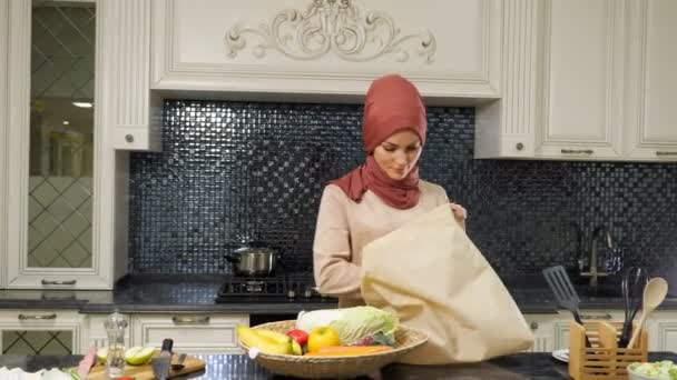 Nő jön a konyhába táska és kiveszi termékek — Stock videók