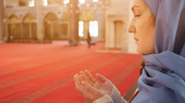 Donna prega tenendosi per mano palme e in piedi in moschea — Foto Stock