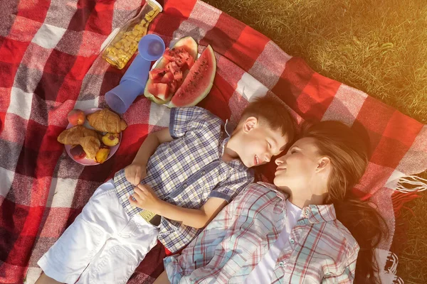 Matka a šťastný syn mluví a smějí se ležet na trávě — Stock fotografie