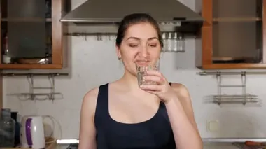 Kız su içiyor ve sağlıklı beslenme alışkanlığını yakından takip ediyor.