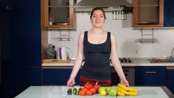 Hezká mladá žena dívá na kameru v kuchyni — Stock video