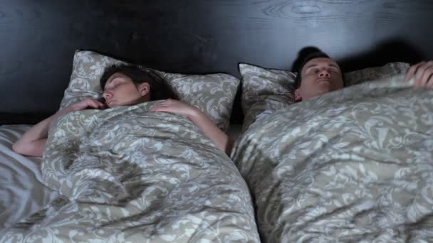 O jovem casal vai para a cama. Rebocador de cobertores — Vídeo de Stock