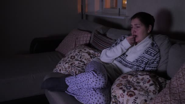 Молодая женщина смотрит страшный фильм в темноте — стоковое видео