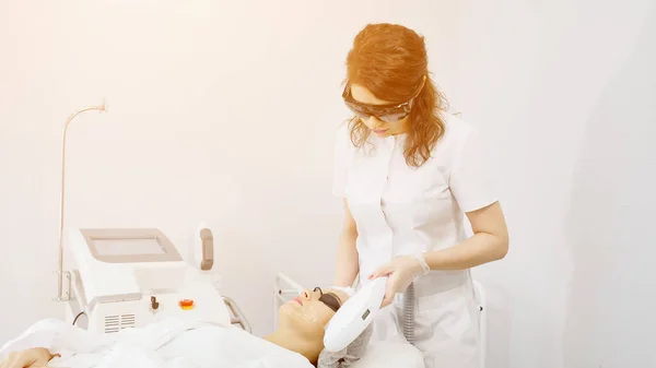 Квалифицированный терапевт делает лазерное удаление волос на лице пациента — стоковое фото