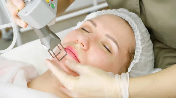 Bonita senhora mentiras e terapeuta faz a remoção de cabelo a laser — Fotografia de Stock