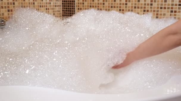 Beaucoup de mousse dans le jacuzzi. Une main de femme touche la mousse — Video