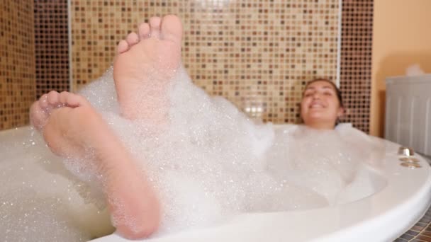 Mujer joven está acostada en un jacuzzi . — Vídeos de Stock