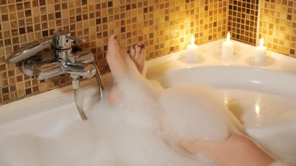 Pés de mulher em um banho de espuma. Relaxamento doméstico — Vídeo de Stock