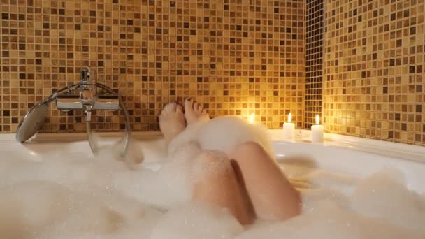 Womens feet in a bubble bath. Home relaxation — Stock Video