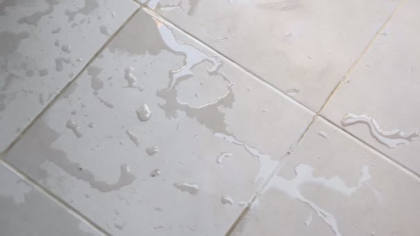 Біла плитка покрита прозорими водними калюжами в домашніх умовах — стокове відео