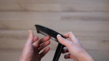 Kişi boş siyah cüzdanı açar ve kahverengi laminatı takar.