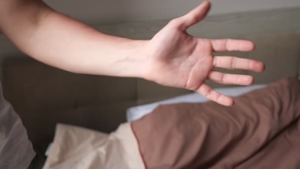 Sporty man touches red sunburned hand in bedroom in morning — Stock Video