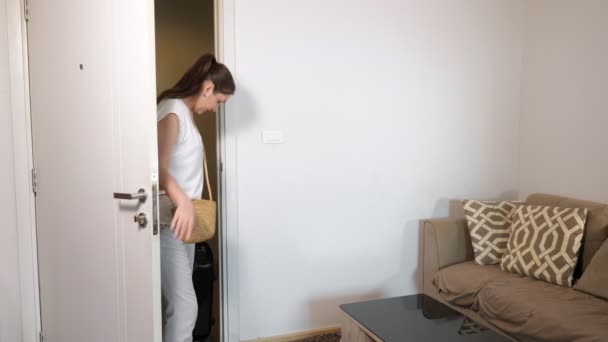 Леди с хвостиком входит в гостиничный номер с большим чемоданом — стоковое видео
