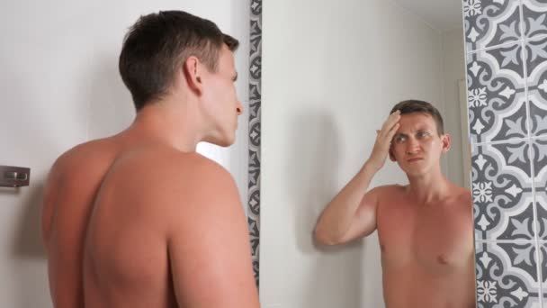 Cara bonito com torso nu olha para rosto queimado pelo sol — Vídeo de Stock