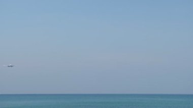 Denizin üzerindeki uçak iniyor. Havaalanı kıyıda.
