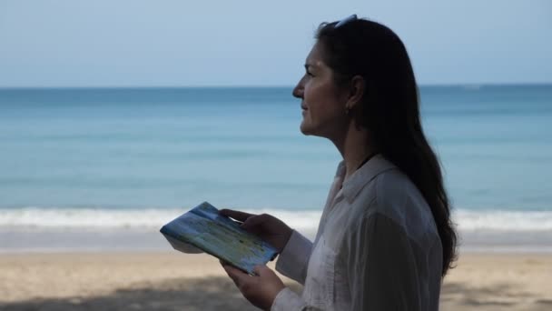 Lady stands and looks at map searching for destination — Stock Video