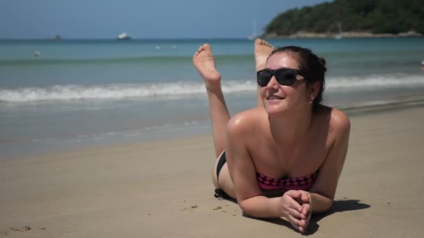 Meisje ligt op zand strand genietend vakantie tegen golven — Stockvideo