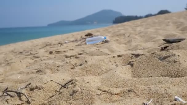 Різні сміття на піску біля моря — стокове відео