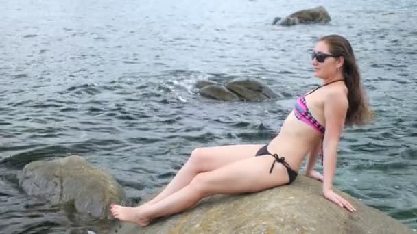 Woman in sunglasses rests lying on stone — Stock Video