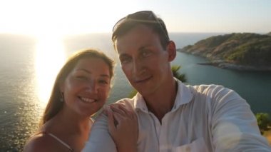 Bir çift selfie çeker, bir kadın da yaz elbisesi giyer.