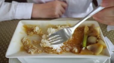 Kadın soslu pilav yiyor. Yüzü olmadan