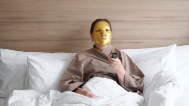 Yüzü altın maskeli ve uzaktan kumandalı bir kadın.