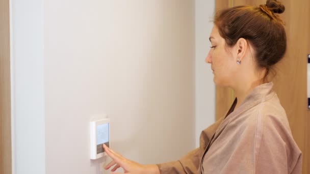 Mujer feliz presiona las teclas del panel de control climático en el hotel — Vídeo de stock