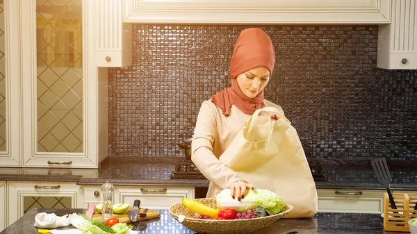 Mulher vem para saco de transporte de cozinha e tira produtos — Fotografia de Stock