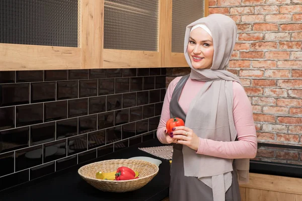 Hermosa mujer musulmana con pimienta en la mano en la cocina — Foto de Stock