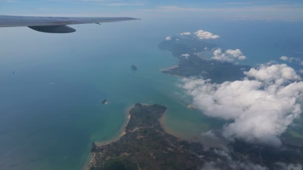 Απομακρυσμένα νησιά στον ωκεανό και λευκό σύννεφο κάτω από την πτέρυγα του αεροπλάνου — Αρχείο Βίντεο