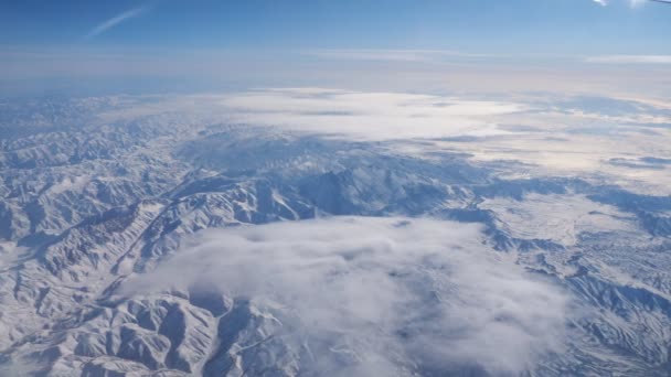 Distância gama de montanhas contra o céu azul da janela do avião — Vídeo de Stock