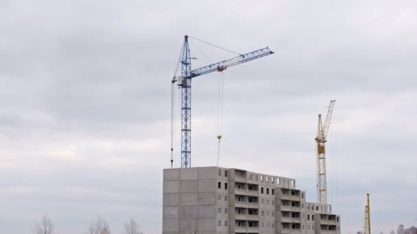 Stavební jeřáby přenášejí betonové desky do stálé budovy — Stock video