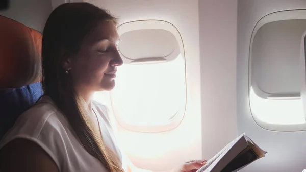 Девушка читает книгу сидя на пассажирском сиденье крупным планом — стоковое фото
