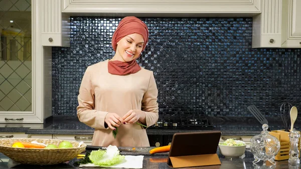 Dama en hijab habla con sus parientes en Skype cocinar cena —  Fotos de Stock