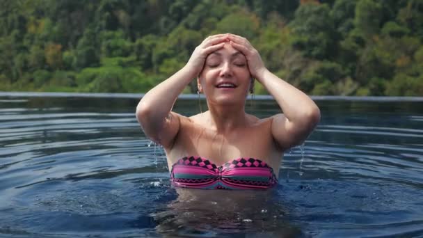 Senhora corrige o cabelo depois de emergir da piscina do hotel — Vídeo de Stock