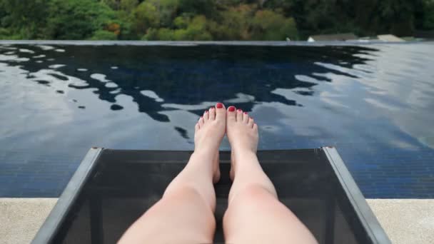 Senhora de biquíni roxo preto fica na espreguiçadeira da piscina do hotel — Vídeo de Stock
