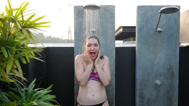 Senhora com cabelo solto treme sob piscina chuveiro água fria — Vídeo de Stock