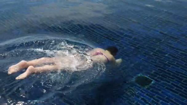 Schwimmerin im Bikini taucht im transparenten Wasser — Stockvideo