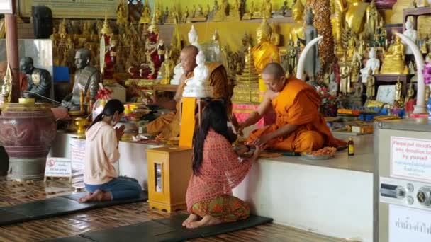 Cestovatelé sedí v blízkosti buddhistických mnichů a provádějí speciální rituály — Stock video