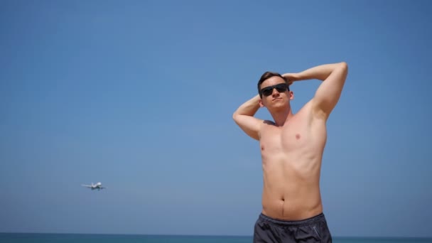 Beau mec aime bronzer contre avion volant dans le ciel — Video