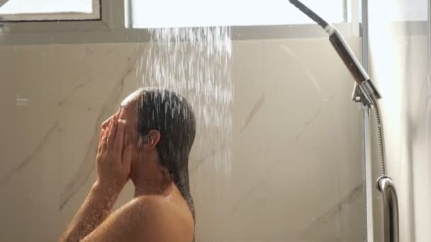 Приваблива брюнетка стоїть під сильним тиском води — стокове відео