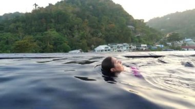 Profesyonel yüzücü mavi otelin havuz suyunda sürüklenir.