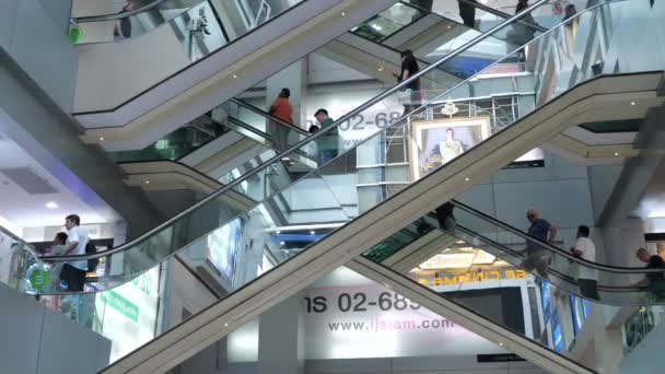 Centro comercial con escaleras mecánicas de vidrio personas que viajan entre pisos — Vídeo de stock