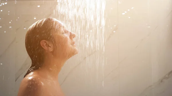 Bella bruna con lunghi capelli bagnati sta sotto getti doccia — Foto Stock