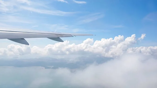Skrzydło samolotu lecącego nad chmurami. — Zdjęcie stockowe