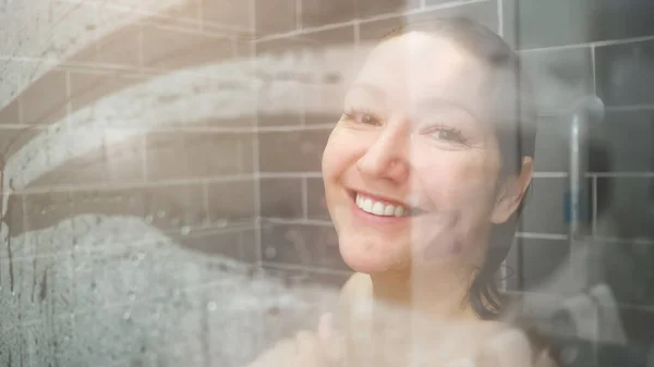Attraktive Dame mit langen nassen Haaren wischt weißes Kondensat ab — Stockfoto