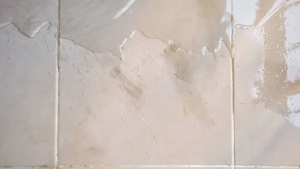 Прозрачная вода распространяется по полу белая плитка — стоковое фото