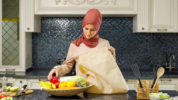 Kvinna kommer till köket väska och tar ut produkter — Stockfoto